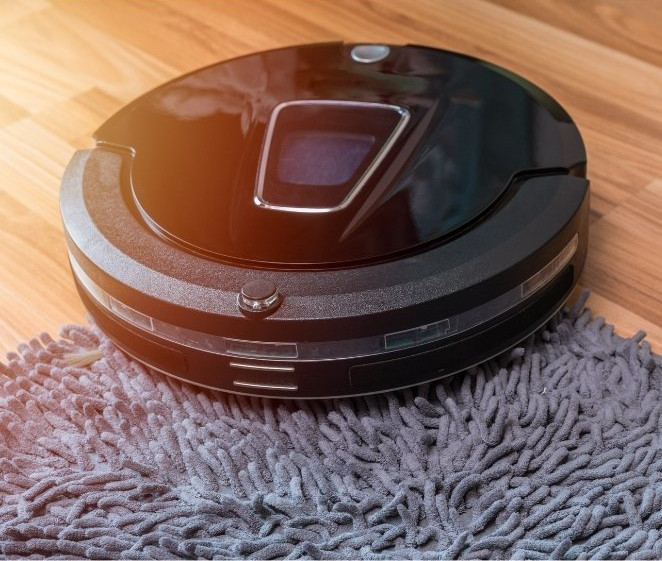 robotdammsugare åker upp på matta med långa fransar